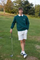 Männliches Model trägt den Alpha Swing Sweater und posiert am Golfplatz. Das Bild betont die Kombination aus Stil und Funktionalität der Golfbekleidung.