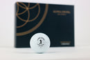 Ein Alpha Edition Golfball von Alpha Swing, mit der Verpackung im Hintergrund sichtbar.