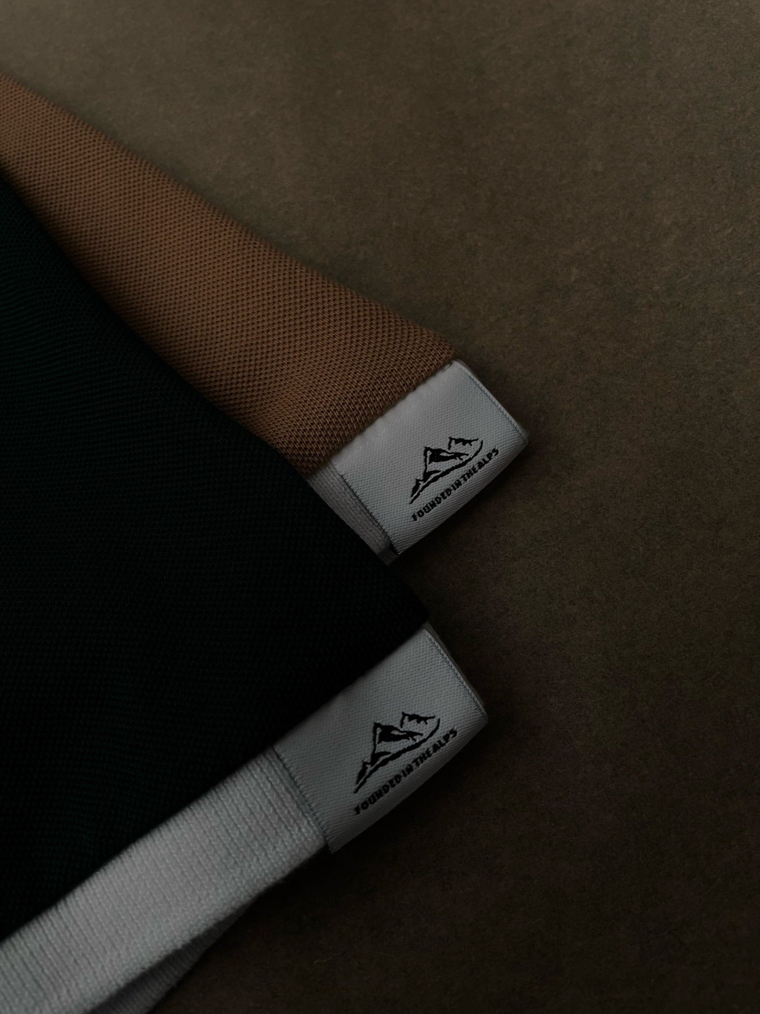 Detailaufnahme von Polo-Shirts mit dem Label 'Founded in the Alps' von Alpha Swing.